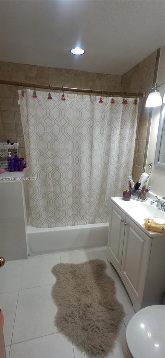 Bathroom featuring white cabinetry, light-toned tile flooring, shower-tub combination with neutral wall tiling, and recessed lighting