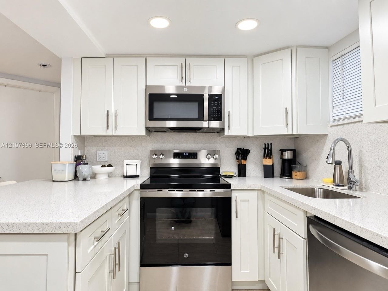 Entryway featuring large-format tile flooring, a six-panel door with matte black hardware, and floor-to-ceiling storage cabinetry with louvered doors