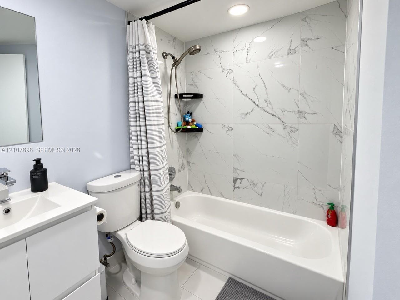 Room featuring wood-finish flooring, a neutral color palette, a flush-mount ceiling light fixture, and an internal storage area with double doors