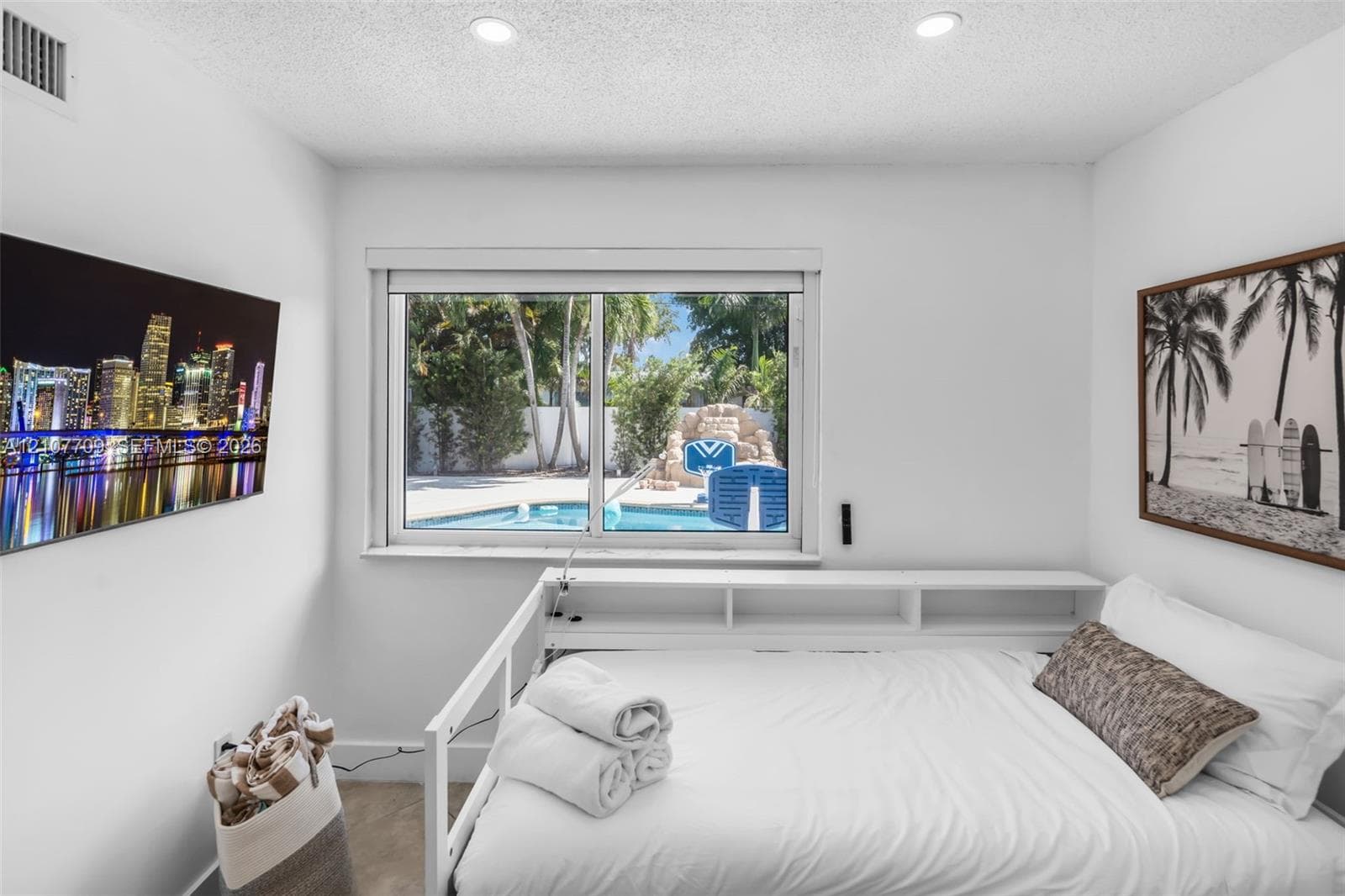 Horizontal sliding window with exterior pool and rock-feature water element, built-in shelving, and recessed ceiling lighting