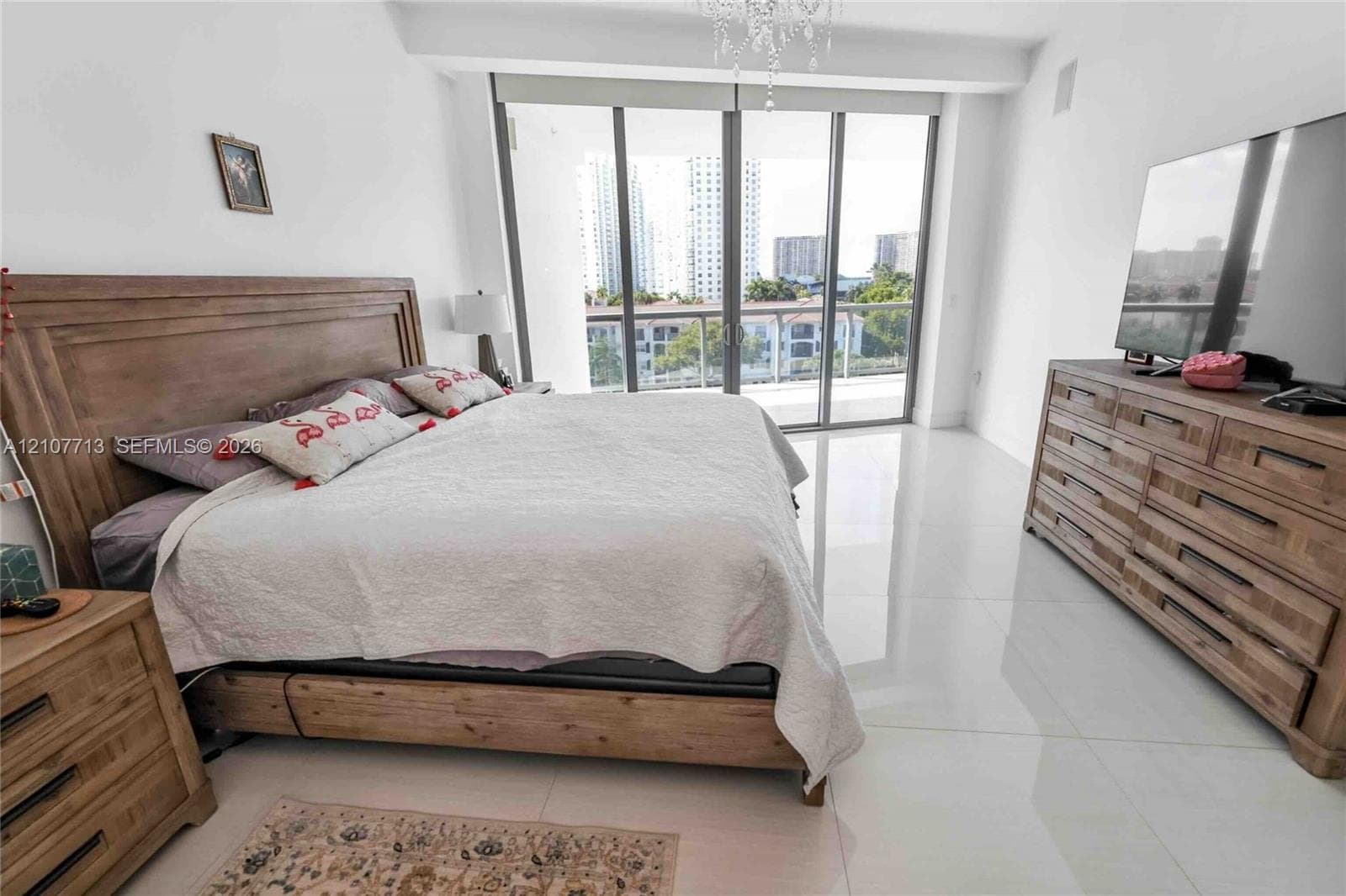 Floor-to-ceiling glass panel door, polished stone flooring, and metal-railed exterior balcony