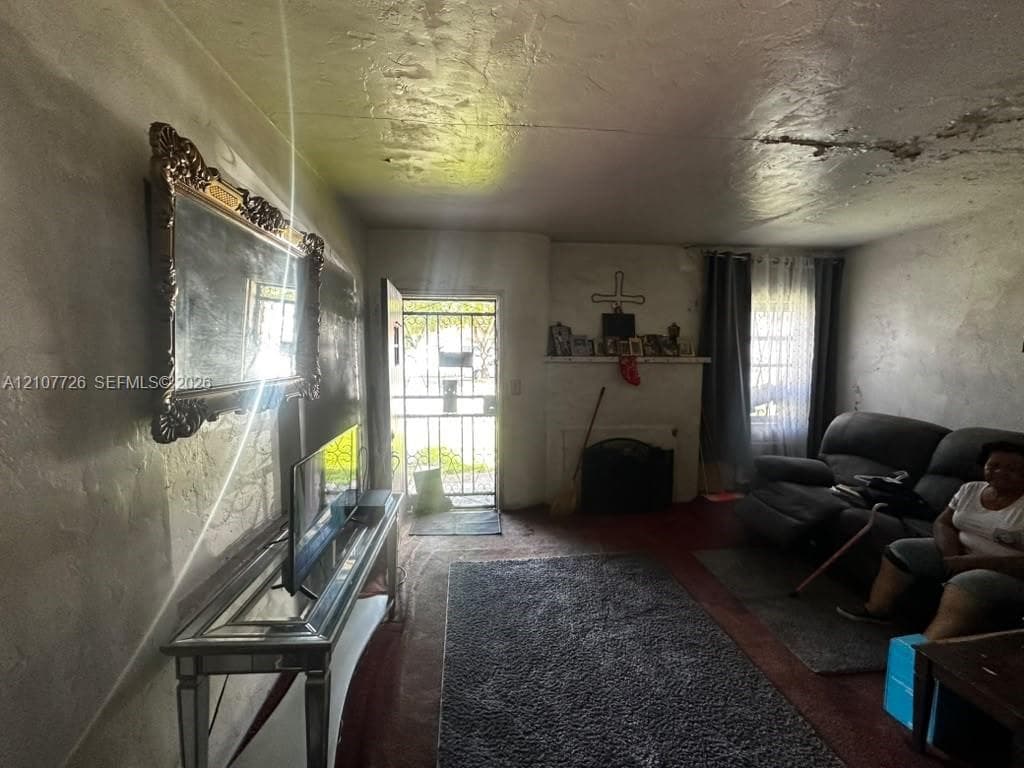 Interior room featuring a built-in mantel, wood-finish flooring, and a metal security storm door