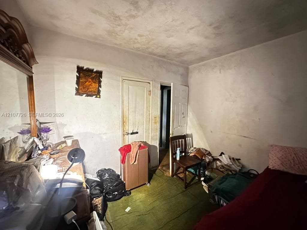 Room featuring wall-to-wall carpeting, two interior doors, and plaster walls