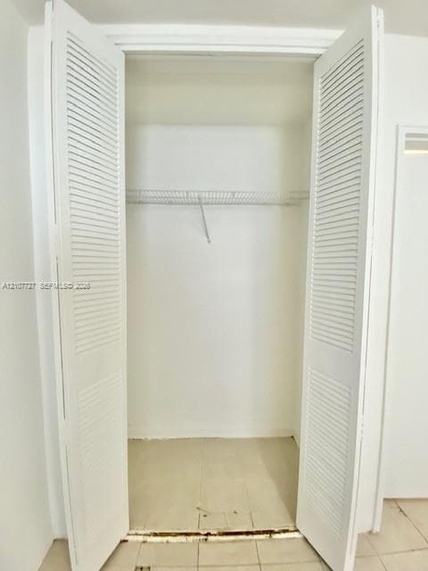 Reach-in closet featuring white louvered bifold doors and wire shelving