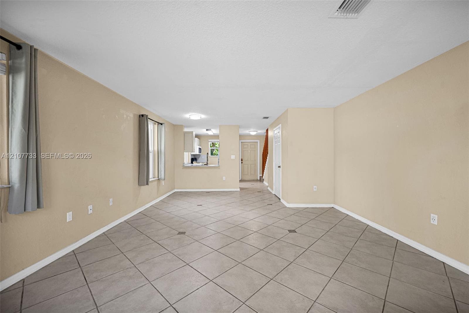 Open-concept interior featuring large-format diagonal tile flooring, neutral wall tones, and recessed ceiling lighting