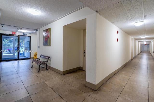 Interior hallway featuring tile flooring, neutral walls, and recessed ceiling lighting
