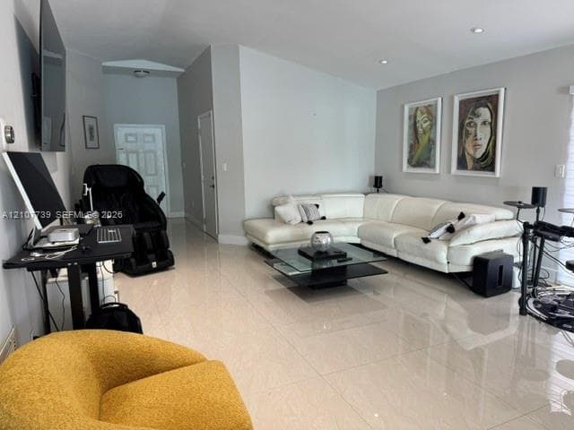Open-concept living space featuring high ceilings, polished tile flooring, and recessed lighting