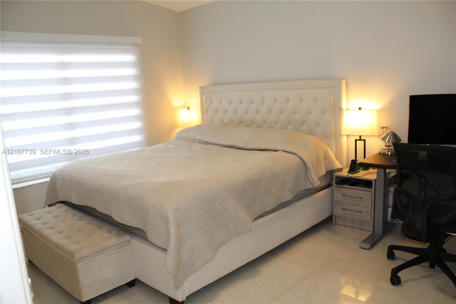 Neutral wall tones, light-toned tiled flooring, and horizontal window shades