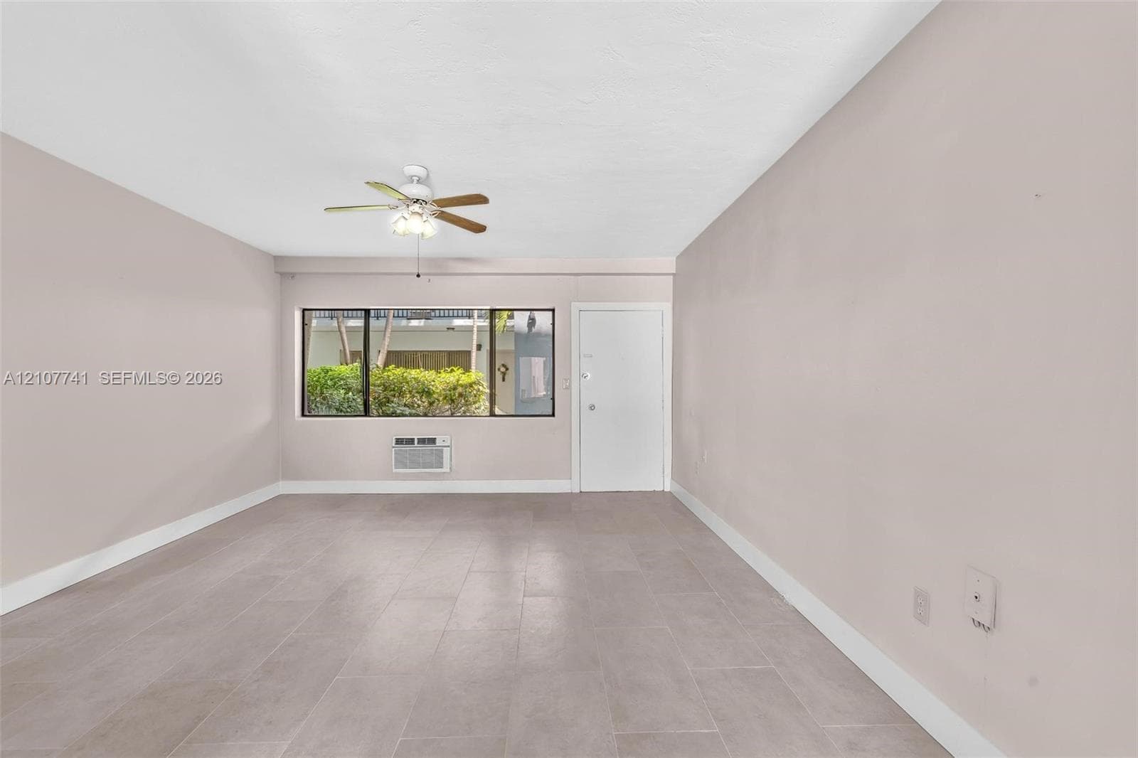 Kitchen featuring white shaker-style cabinetry, stainless steel dishwasher, brick-accented breakfast bar, tile flooring, and dual ceiling fans