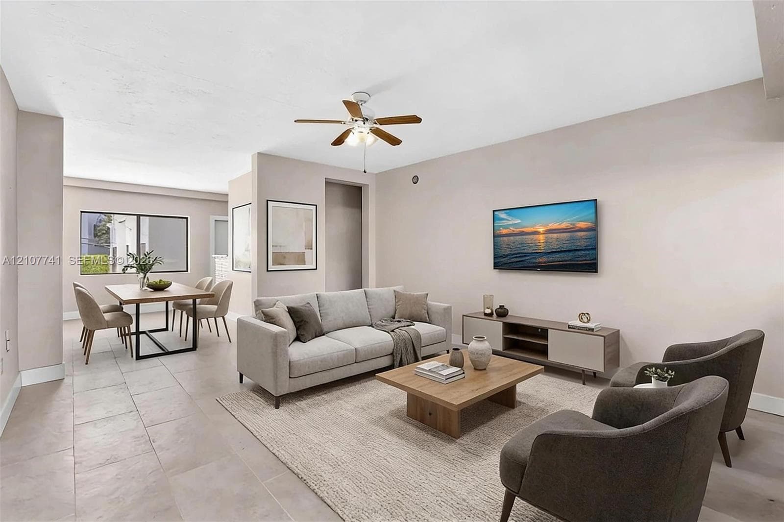 Neutral-toned tile flooring, solid-core interior doors, and a ceiling-mounted light fixture with a three-blade fan