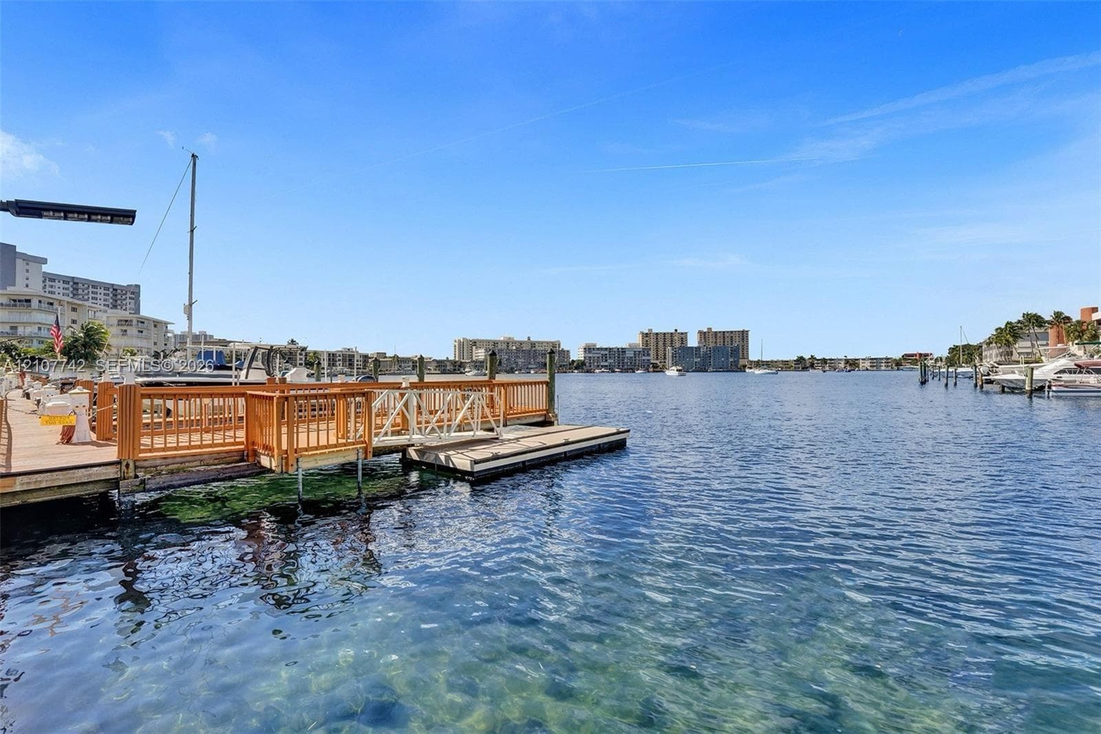 Waterfront bulkhead with a wooden dock featuring a ramp and integrated pilings