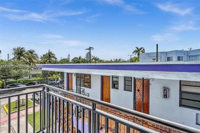 Elevated exterior balcony featuring metal railings, tile flooring, and integrated metal security door framing
