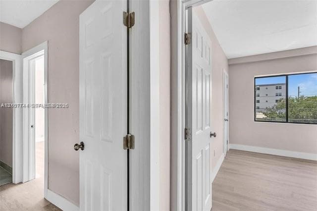 Interior space featuring wood-finish flooring, six-panel interior doors, and a single-pane horizontal window