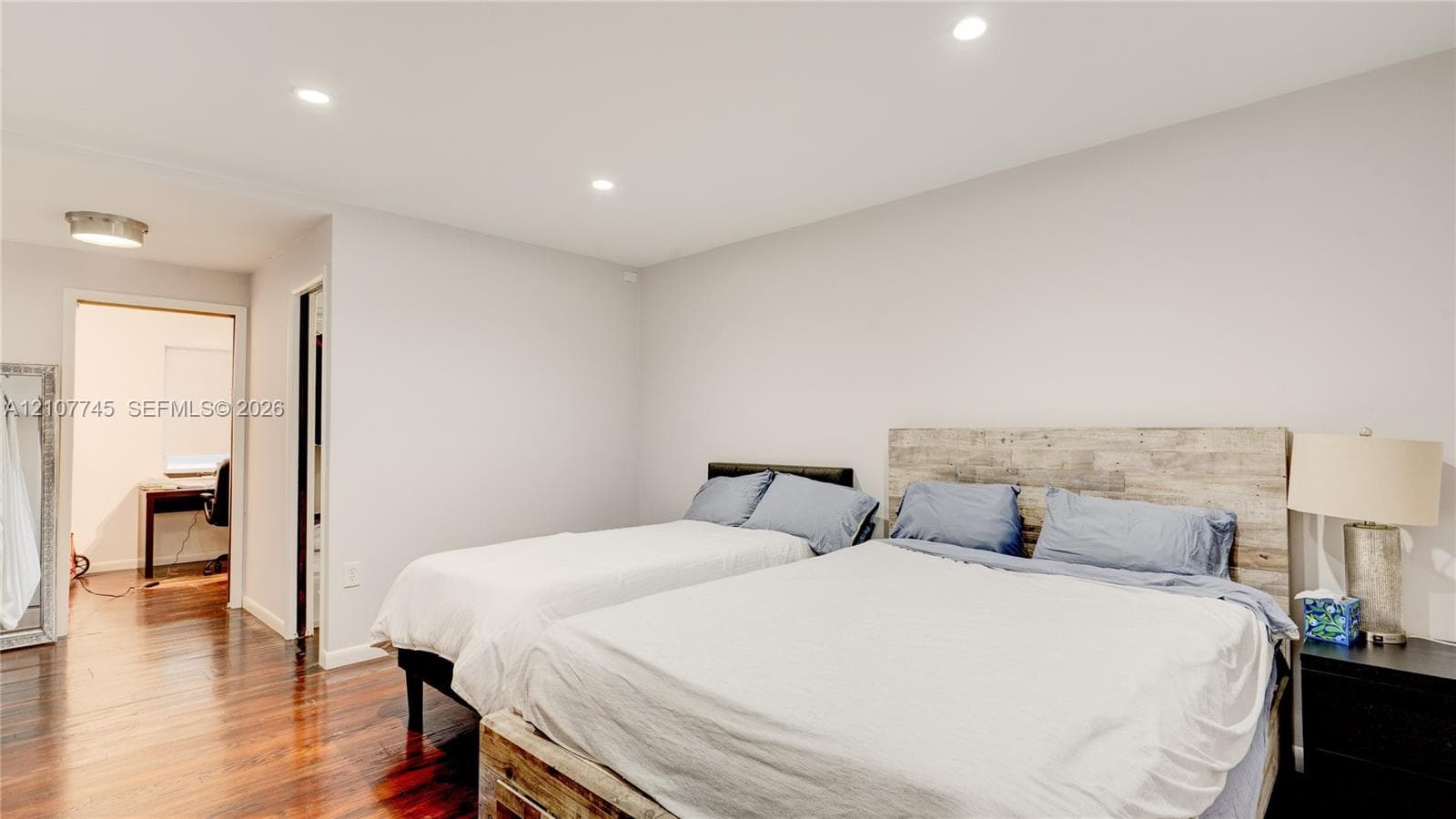 Neutral-toned interior featuring dark wood-finish flooring and recessed LED lighting