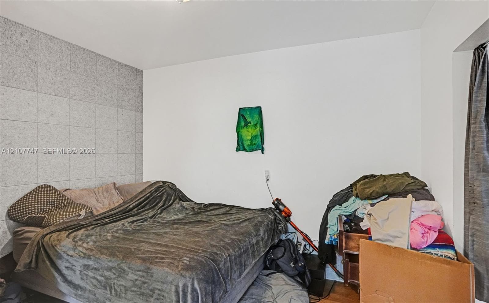 Room featuring a textured accent wall and wood-finish flooring