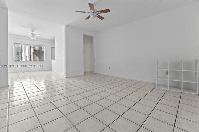 Open interior featuring ceramic tile flooring, neutral wall tones, and ceiling fans with integrated lighting fixtures