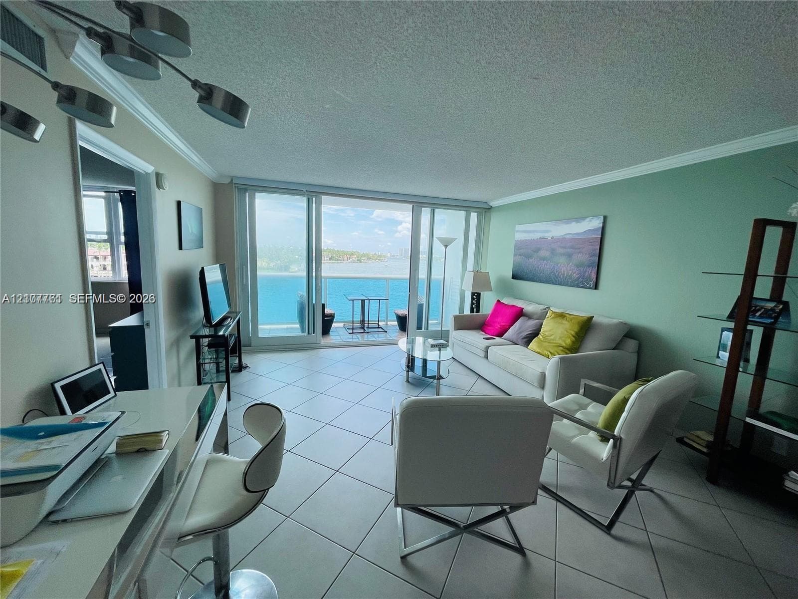Living area featuring large-format ceramic tile flooring, multi-panel sliding glass doors, and recessed track lighting