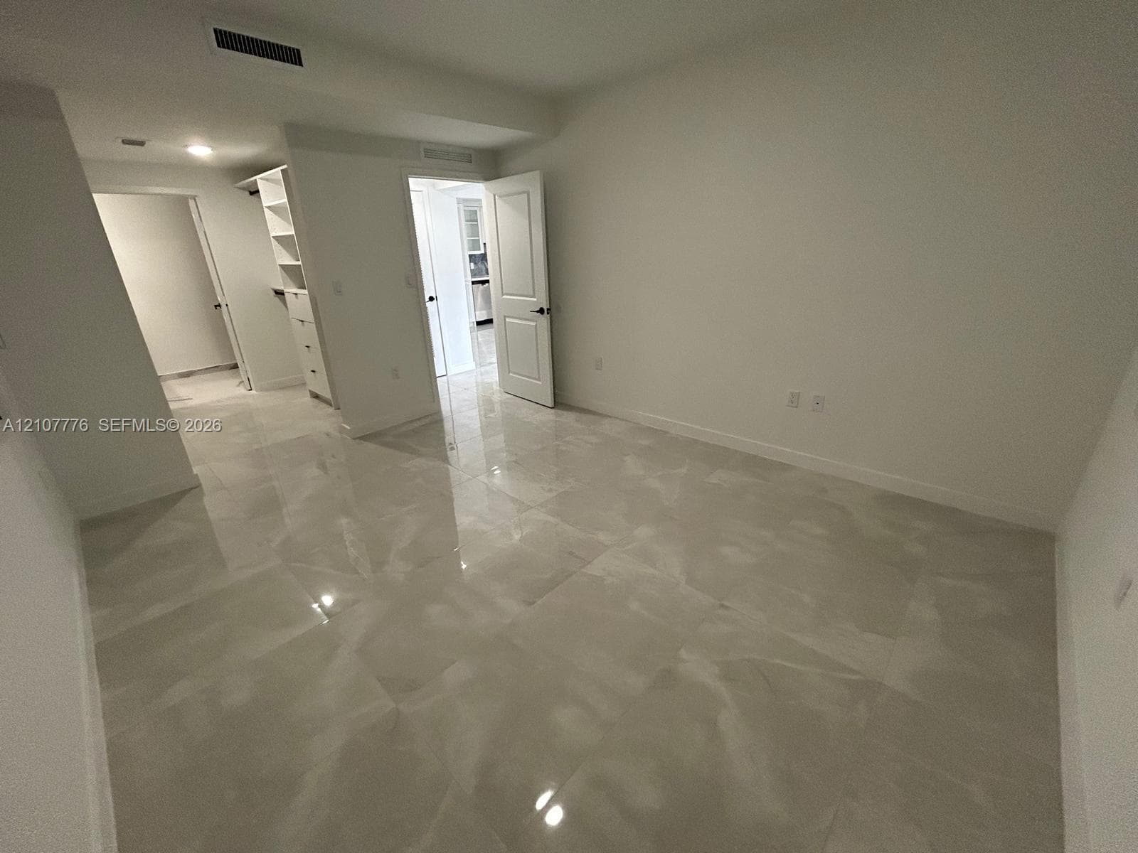 Interior room featuring large-format tile flooring, built-in shelving, and recessed ceiling lighting