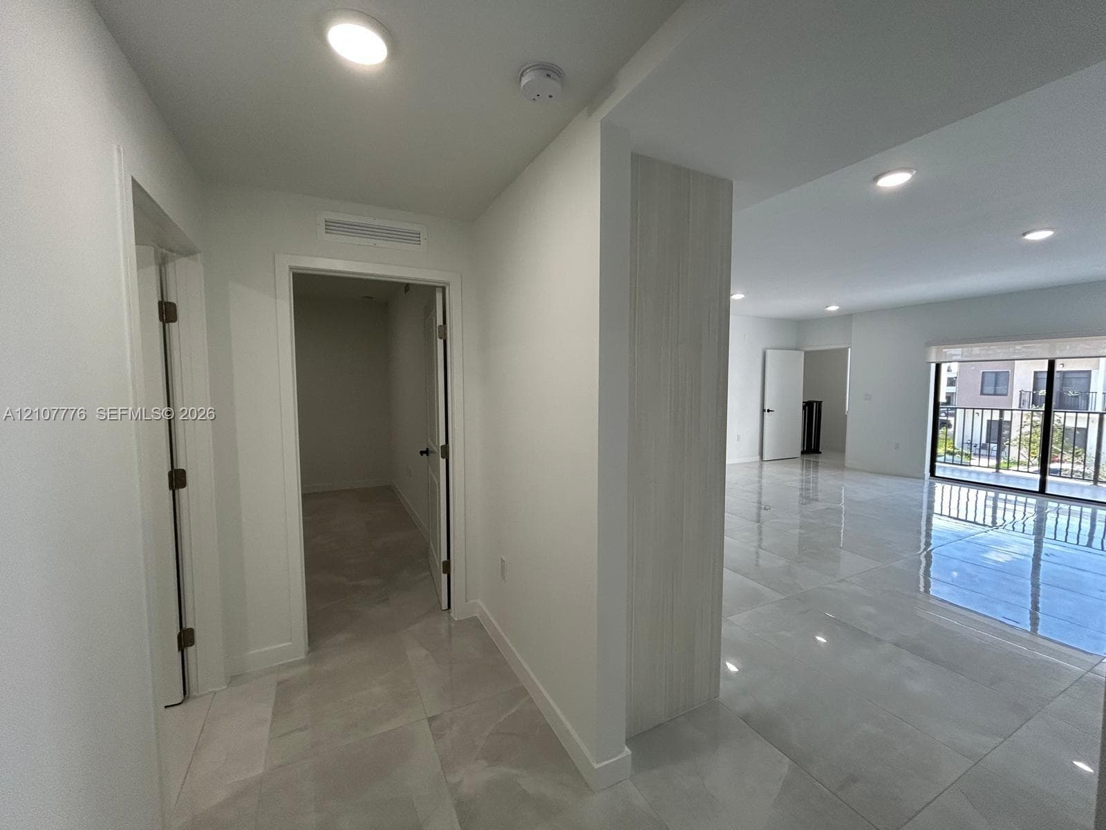 Large-format polished tile flooring, recessed ceiling lighting, and a neutral color palette