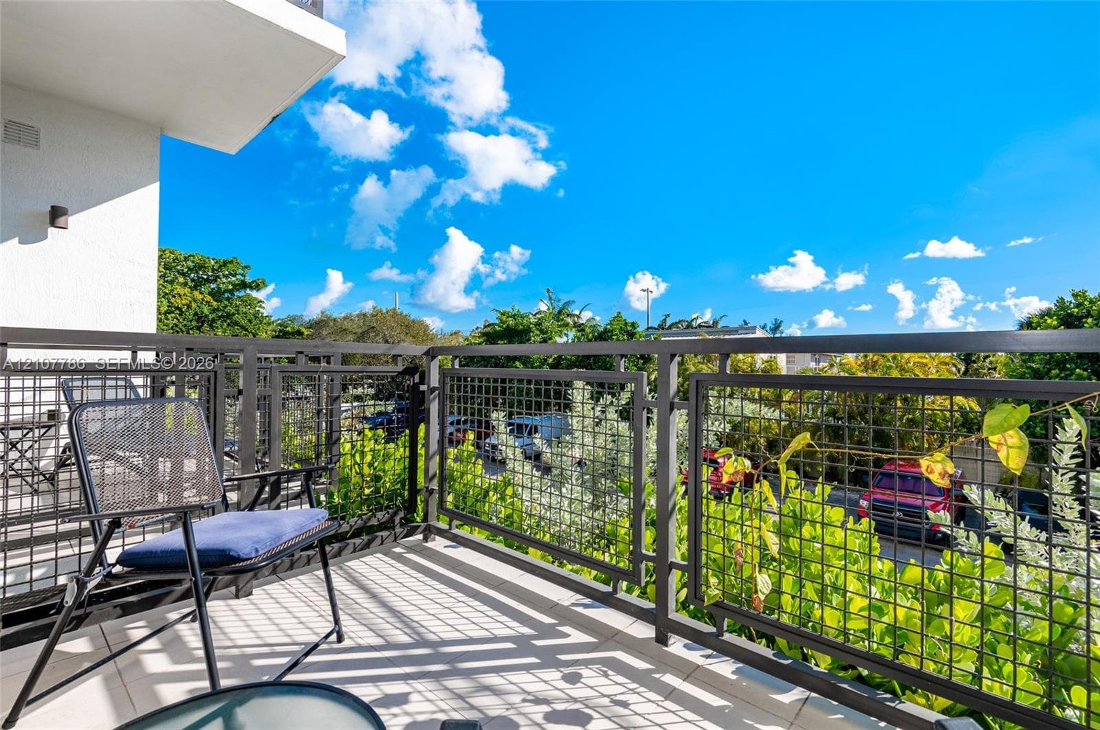 Private balcony featuring a geometric metal grid railing and light-toned tile flooring