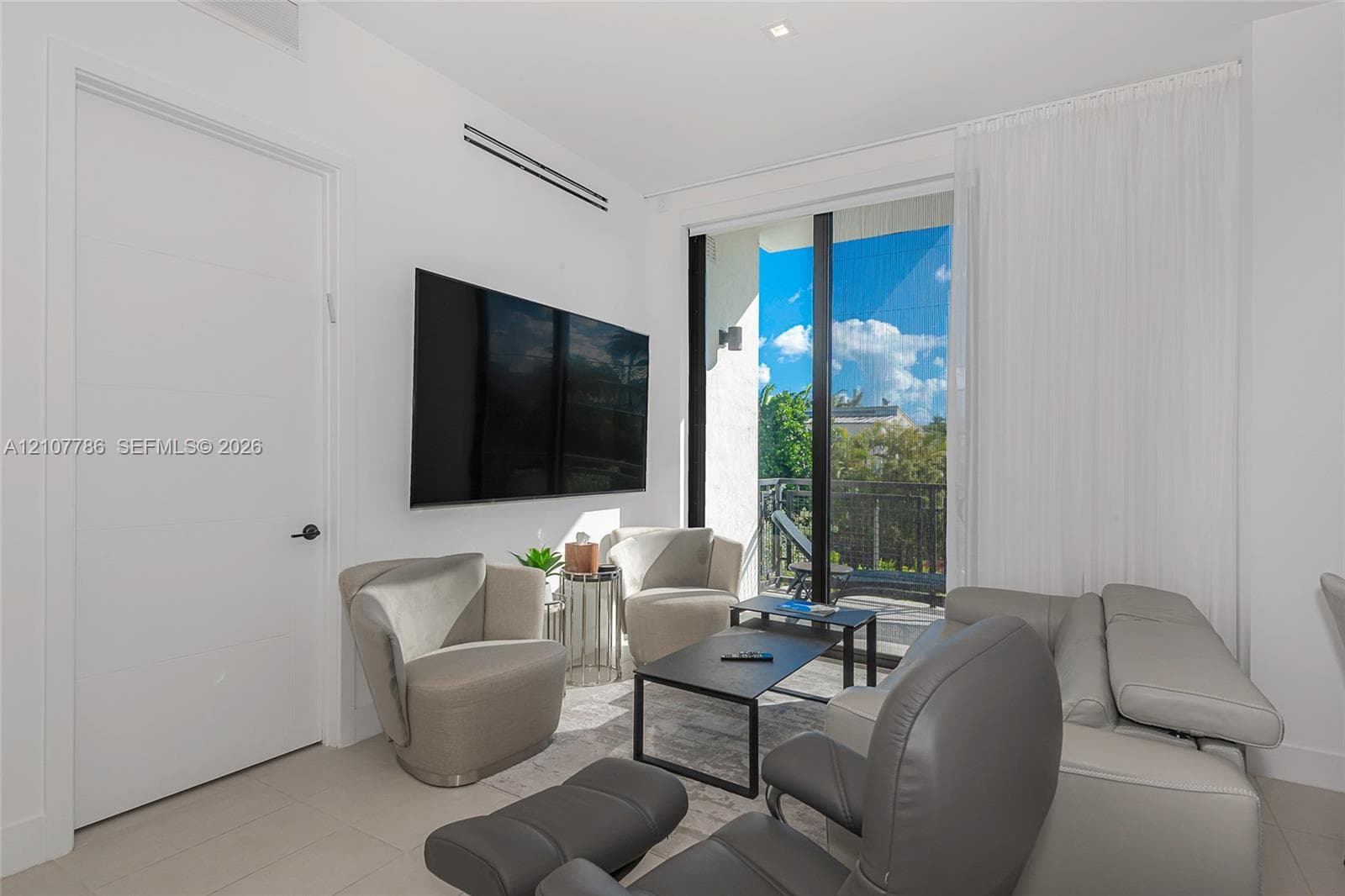 Floor-to-ceiling glass sliding doors, neutral tile flooring, recessed linear ceiling light, and balcony access