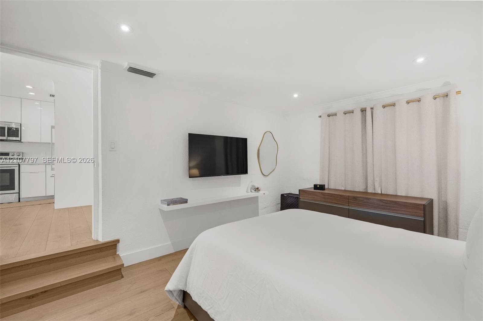 Room featuring light wood-finish flooring, recessed lighting, and a wall-mounted floating shelf