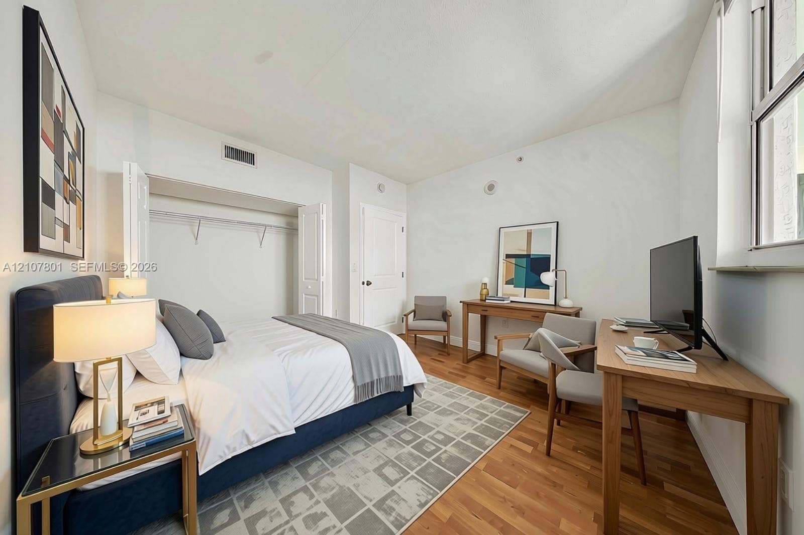 VIRTUALLY STAGED - Room featuring wood-finish flooring, a built-in closet with double-hinged doors, and a large window