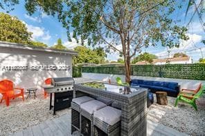 Outdoor patio featuring a gravel ground cover, perimeter wall with integrated greenery, and an exterior wall finished in neutral stucco