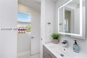 Modern vanity with a rectangular integrated sink, chrome faucet, and rectangular wall-mounted LED-backlit mirror