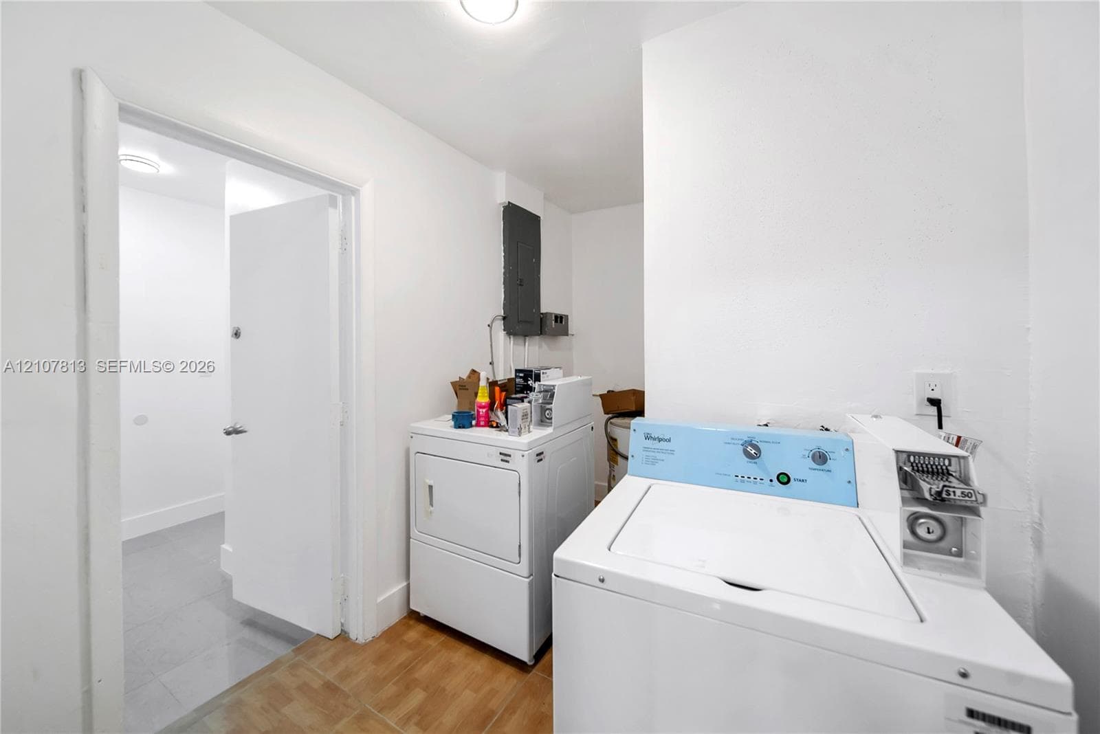 Utility area featuring ceramic tile flooring, neutral walls, and a dedicated electrical panel