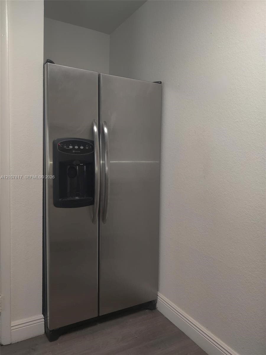 Stainless steel side-by-side refrigerator featuring an integrated water and ice dispenser