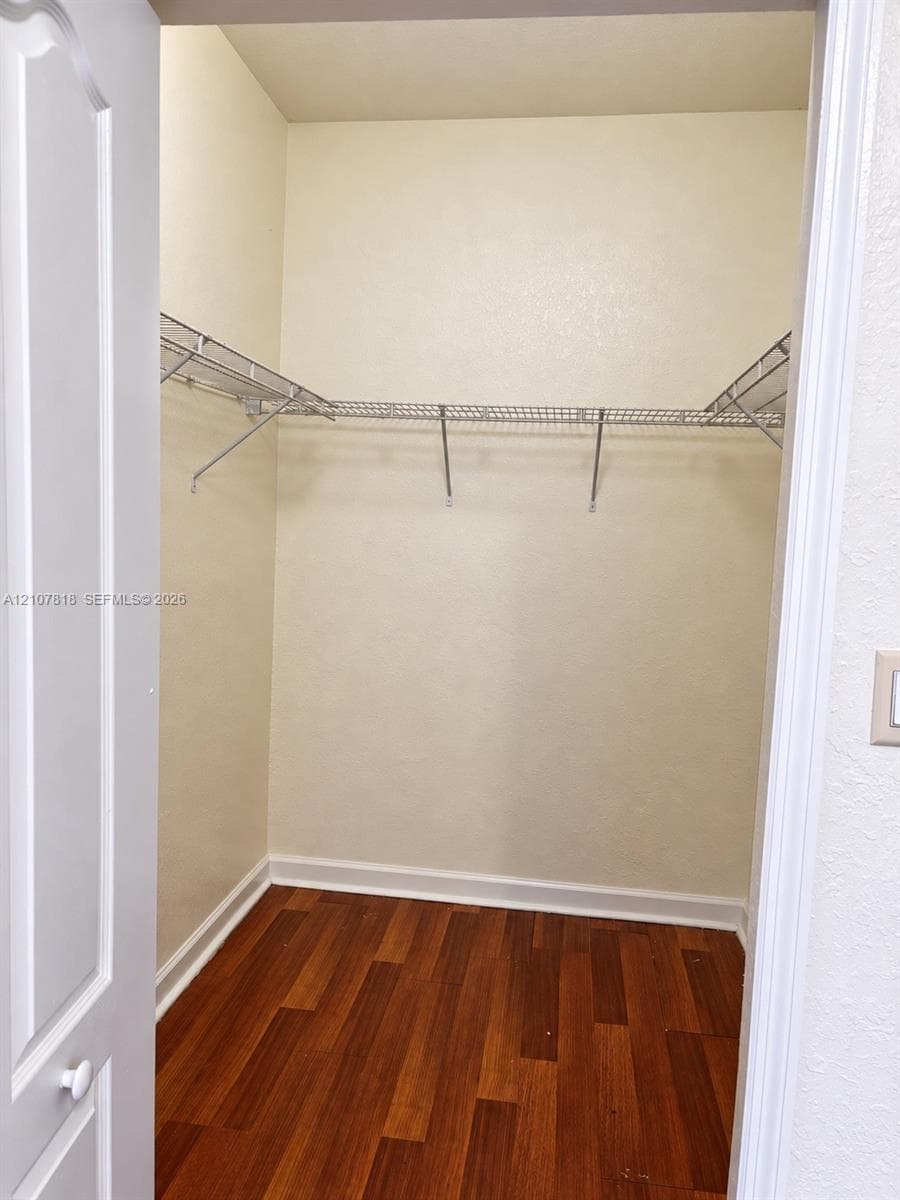 Storage closet featuring wood-finish flooring and integrated wire shelving