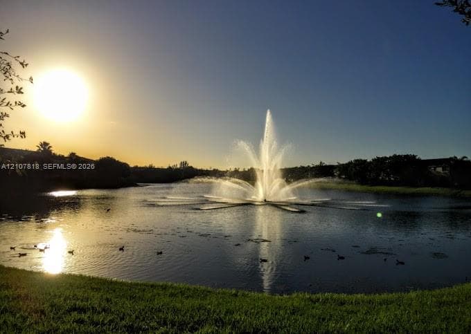 Expansive lake featuring a central tiered water fountain and manicured grass perimeter