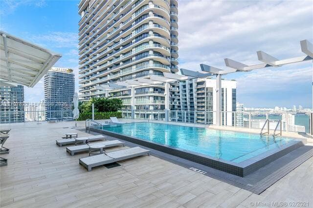 Rooftop pool featuring a tile deck, custom pergola structure, glass perimeter railing, and integrated stainless steel ladder