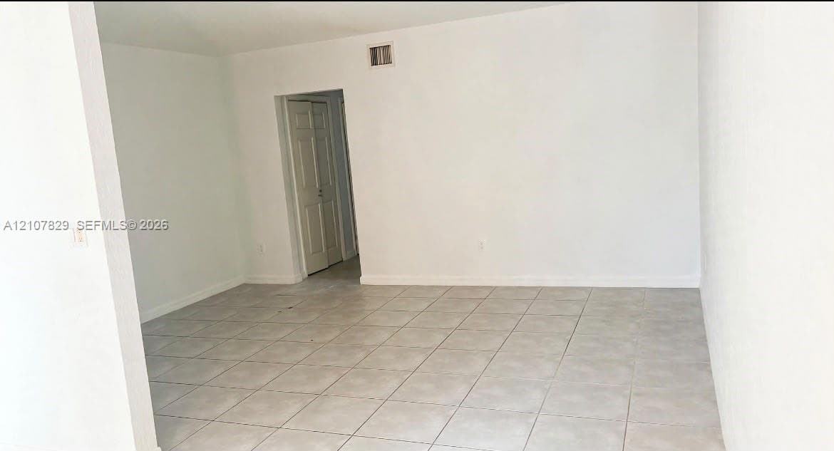 Interior space featuring neutral wall tones, large-format ceramic tile flooring, and multi-panel swinging doors