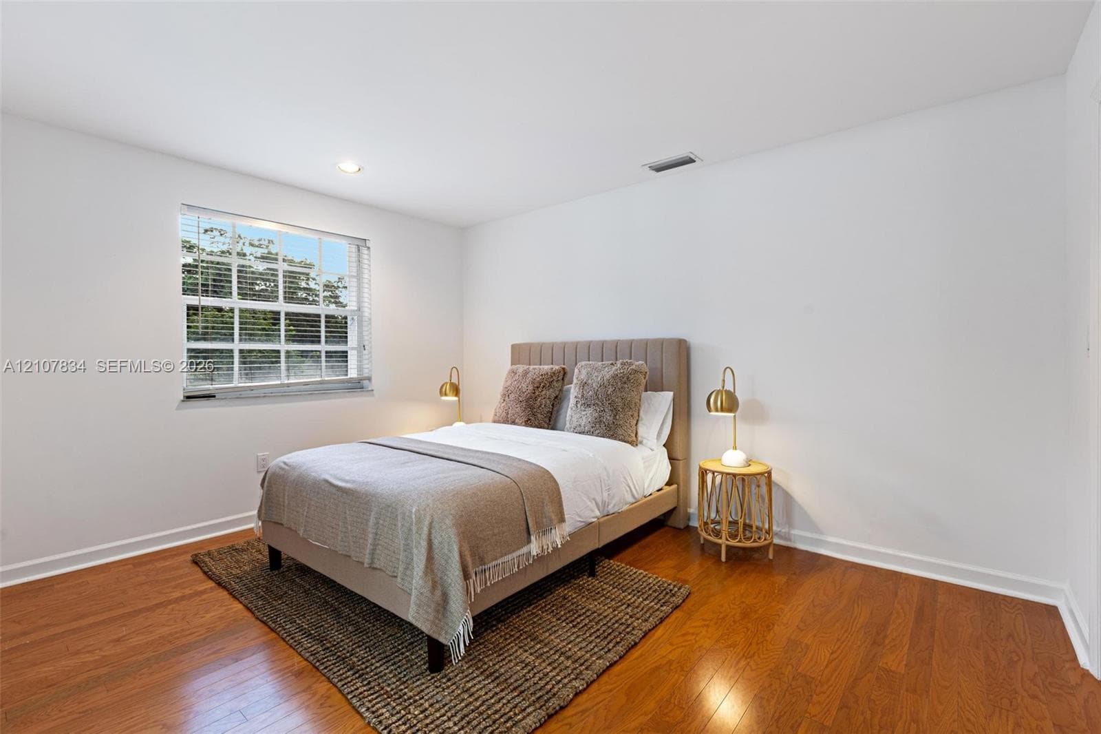 Wood-finish flooring, recessed ceiling lighting, and a multi-pane window