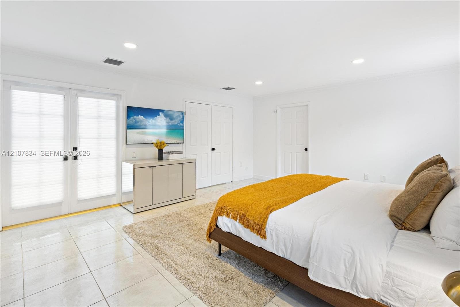 Neutral-toned interior space featuring white ceramic tile flooring, double glass-panel doors with integrated blinds, recessed lighting, and white six-panel interior doors