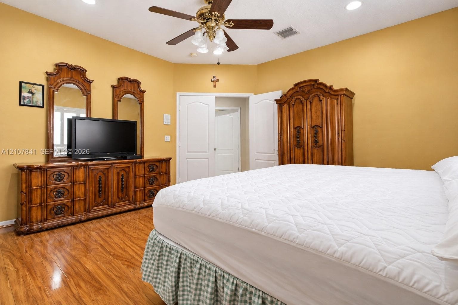 Wood-finish flooring, recessed lighting, and a multi-light ceiling fan