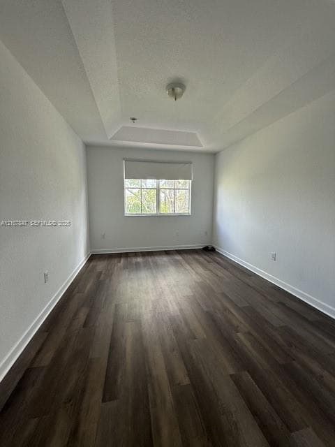 Tray ceiling, wood-finish flooring, and single-pane window with roller shade