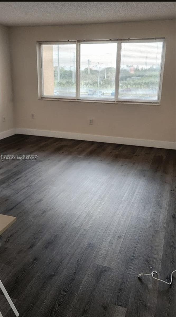 Interior space featuring wood-finish flooring, neutral wall tones, and a multi-pane window