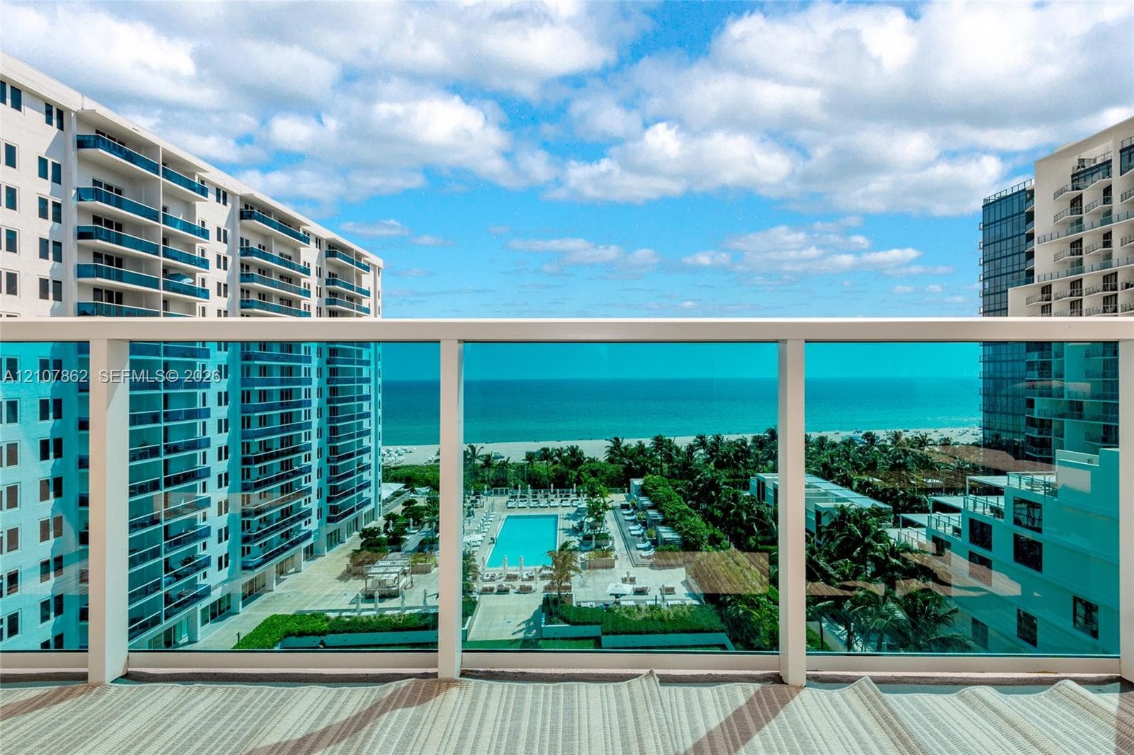 Balcony featuring a glass panel railing and ocean scenery