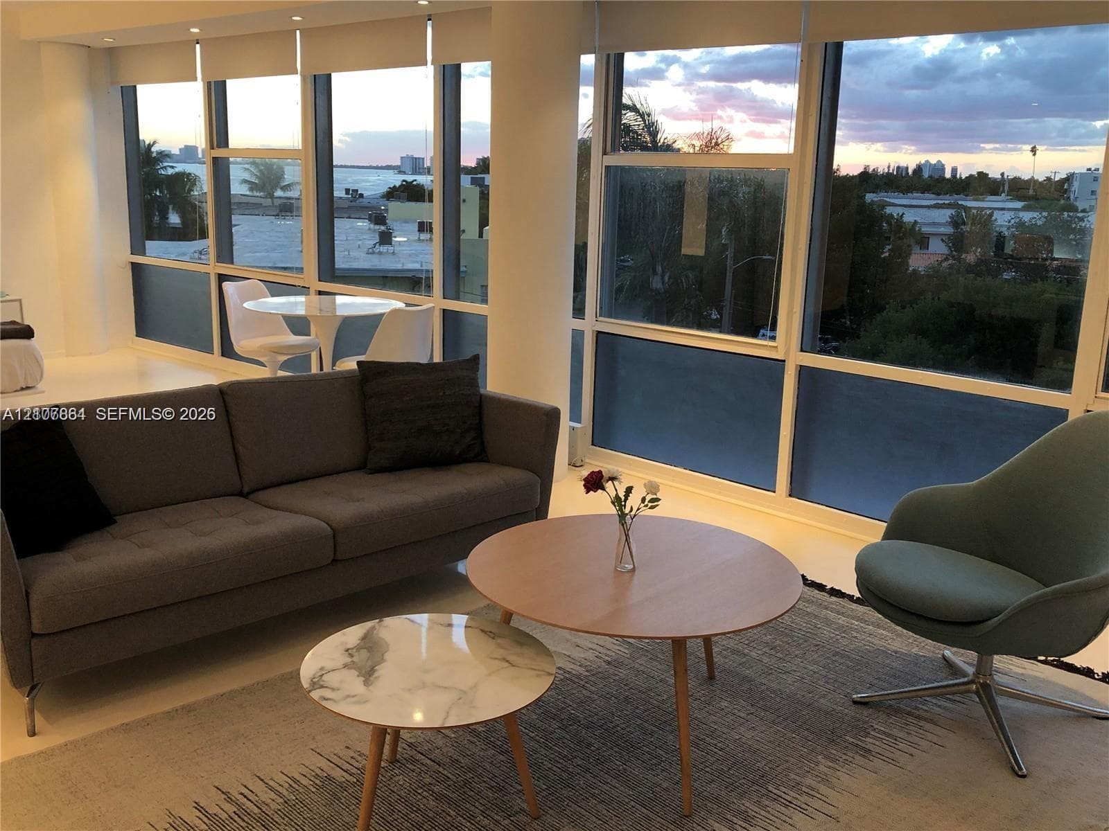 Floor-to-ceiling windows with expansive water and city outlooks, featuring white-frame casements and integrated roller shades
