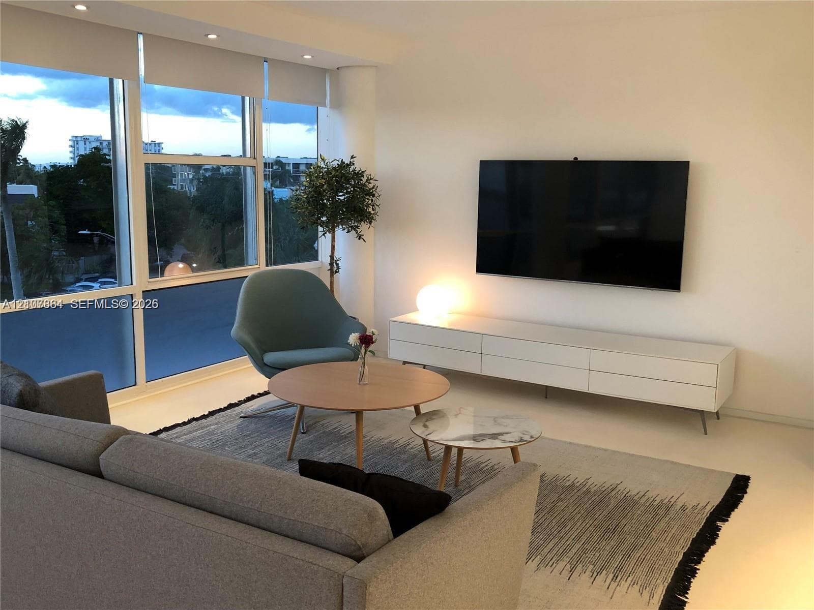 Floor-to-ceiling windows featuring automated roller shades, recessed lighting, and smooth-finish flooring