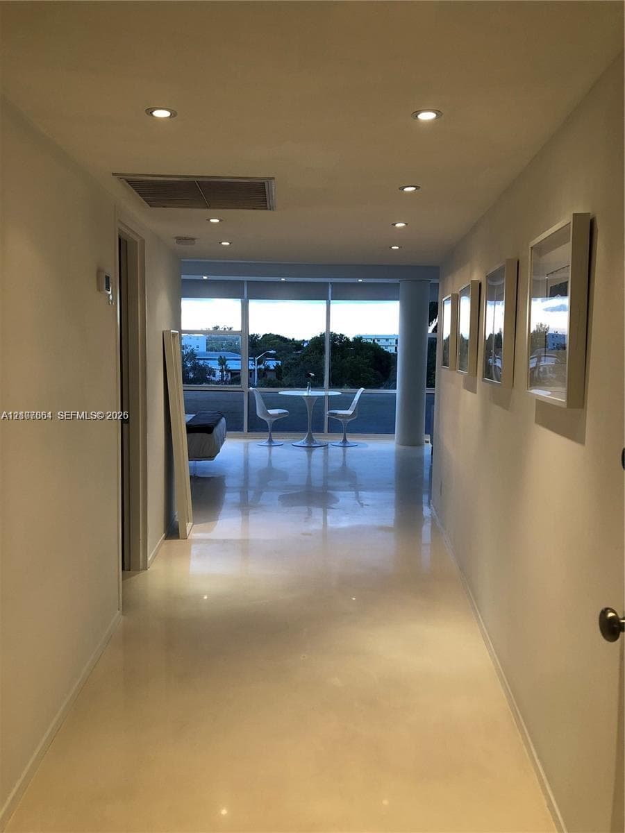 Polished light-toned flooring, recessed ceiling lighting, and floor-to-ceiling glass paneling