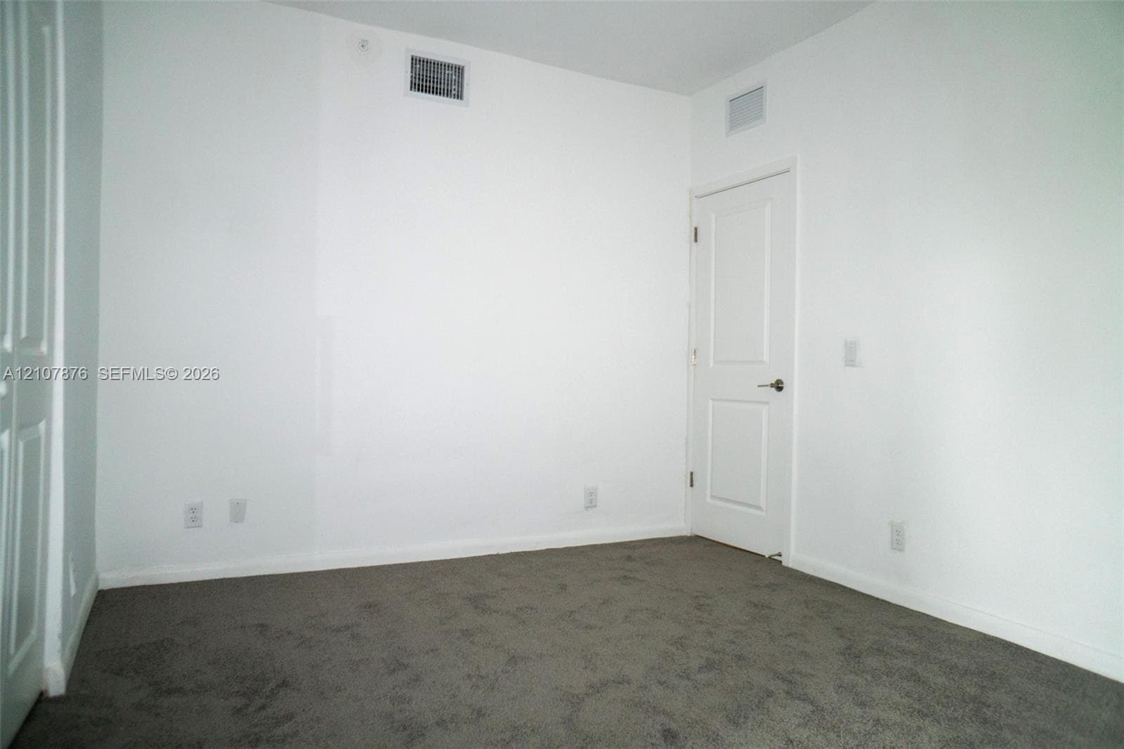 Neutral-toned carpeted flooring, two-panel interior door, and smooth walls