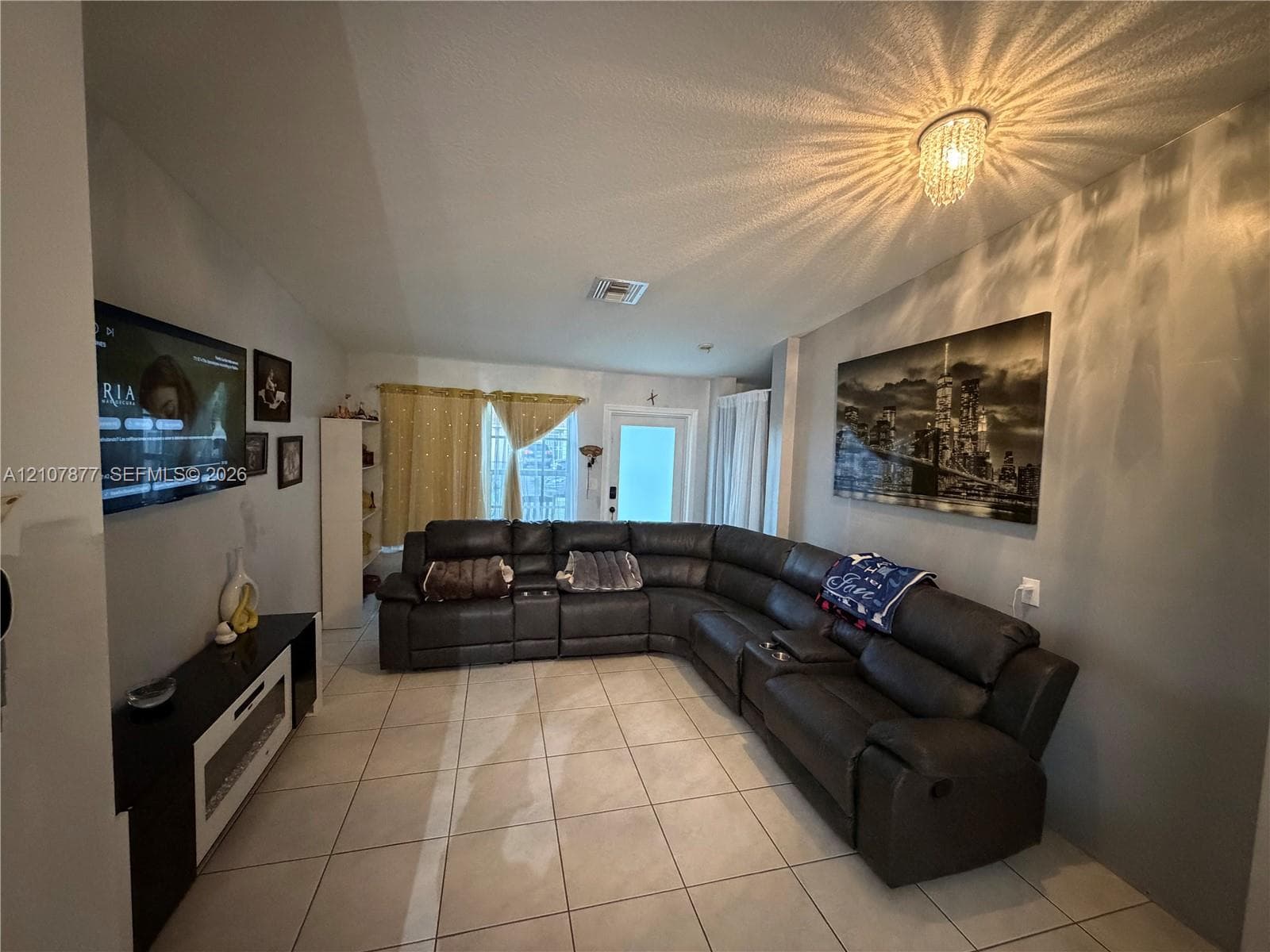 Ceramic tile flooring throughout with a tiered crystal flush-mount light fixture