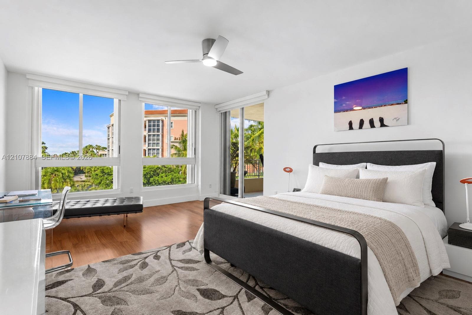 Wood-finish flooring, floor-to-ceiling windows, sliding glass door, and a modern ceiling fan