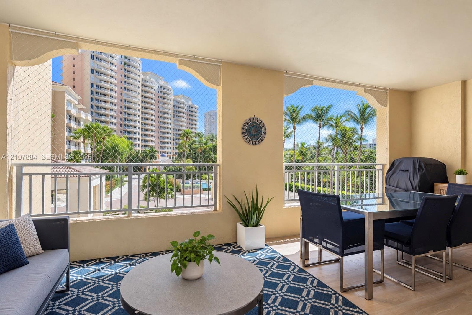 Covered outdoor balcony featuring neutral stucco walls, arched architectural openings, metal safety railings, and overhead recessed lighting