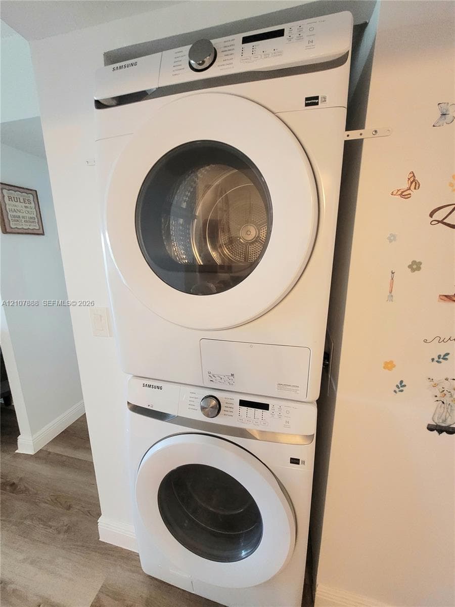 Stacked white Samsung washer and dryer unit with front-loading glass doors and integrated digital control panels