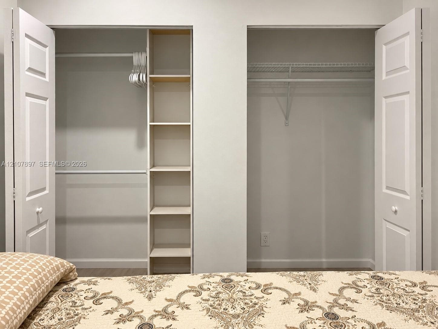 Dual reach-in closets featuring white paneled bifold doors, integrated shelving, and white wire rack systems